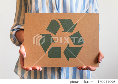 Female hands holding signboard recycling reusing zero waste circular arrow go green closeup Female hands holding signboard recycling reusing zero waste circular arrow go green closeup 120914096