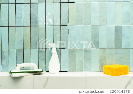 Applying epoxy grout and adhesive to ceramic tiles in a bright bathroom space. 120914178