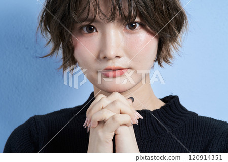 一個留著短髮、看起來在祈禱的年輕女子 120914351