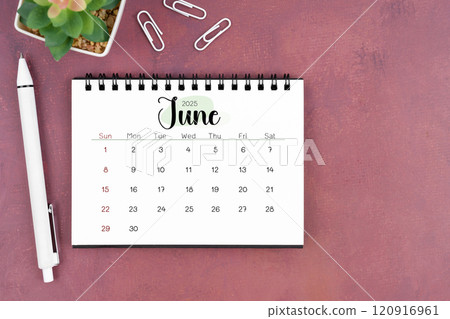 June desk calendar for 2025 year and pen on old red cover. Flat lay. 120916961
