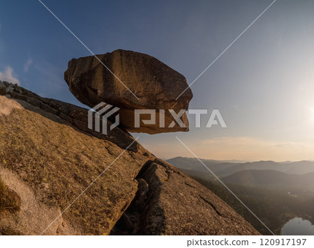 Large granite boulder hangs over the abyss. 120917197