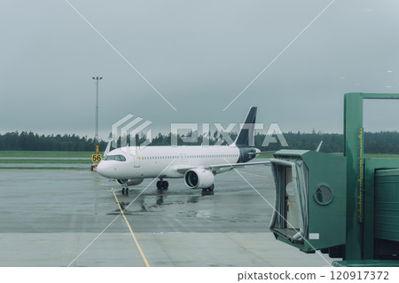 Airport on a rainy day and parked passenger planes Airport on a rainy day and parked passenger planes 120917372