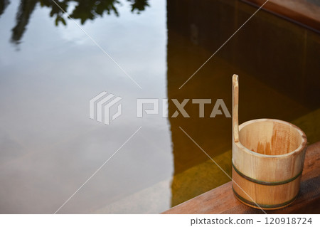 A cypress bucket placed in an open-air cypress bath with steam rising from it A cypress bucket placed in an open-air cypress bath with steam rising from it 120918724