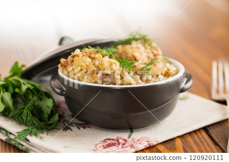 cooked boiled buckwheat with chicken meatballs in ceramic bowl on wooden table 120920111