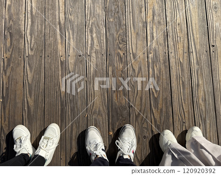 木紋地板上的三名男女腳和鞋子 — 人體部位設計背景材料 木紋地板上的三名男女腳和鞋子 — 人體部位設計背景材料 120920392