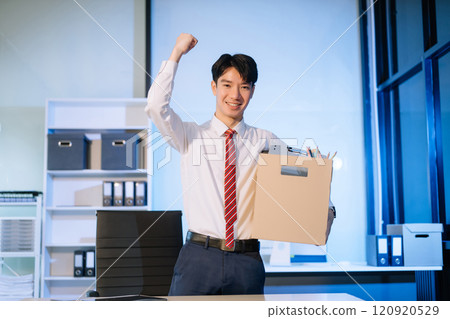 young  Asian man office worker celebrating her resignation, carrying her personal stuff. leaving job, changing or company 120920529