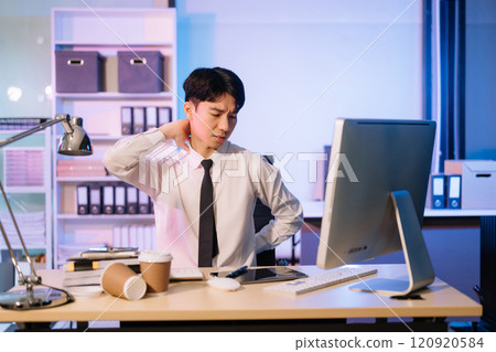 Overtime work concept, Handsome asian business man working overtime sitting at desk using computer and doing overtime project 120920584