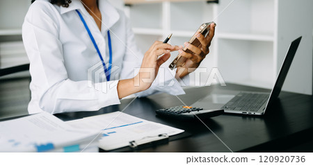 Women counting coins on calculator taking from the piggy bank. hand holding pen working on calculator Women counting coins on calculator taking from the piggy bank. hand holding pen working on calculator 120920736