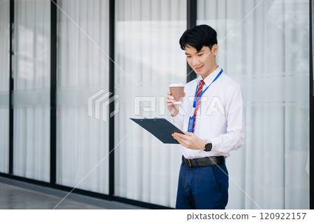 Young Asian businessman leader entrepreneur, professional manager holding digital tablet computer on the street in big city 120922157