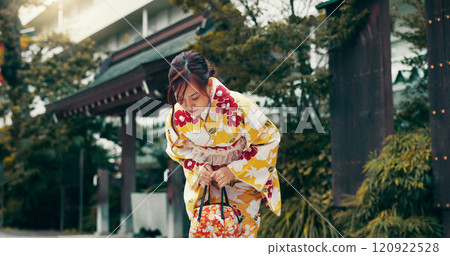 Bow, kimono and Asian woman in city for ceremony, ritual and respect at temple in Japan. Outdoors, culture and person in traditional clothes with gesture for gratitude, prayer and custom in town 120922528