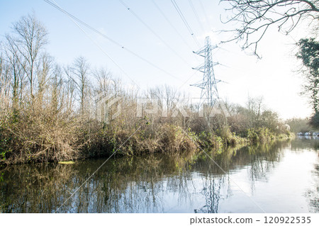 A large steel tower standing beside a canal in Colne Valley, a suburb of London, under a clear blue sky A large steel tower standing beside a canal in Colne Valley, a suburb of London, under a clear blue sky 120922535