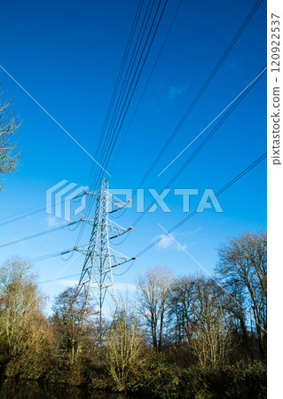 A large steel tower standing beside a canal in Colne Valley, a suburb of London, under a clear blue sky 120922537