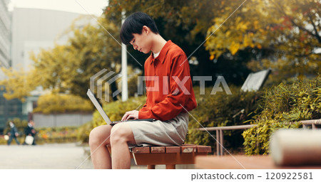 Man, student and laptop in park for typing, planning and creative writing for travel blog in Japan. Japanese person, computer or connectivity in Tokyo for social media post, journal editing and email 120922581