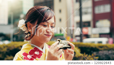 City, smile and girl in kimono eating onigiri on street with happy face, morning commute and breakfast snack. Urban, rice ball and woman with traditional Japanese clothes, food and culture for travel 120922643