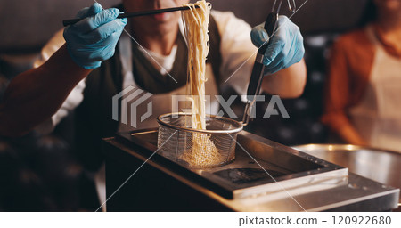 Japan, restaurant and hands cooking noodles for traditional cuisine, culinary culture and meal preparation. People, gloves and steaming ramen with chopsticks for nutrition, lunch and healthy dinner 120922680