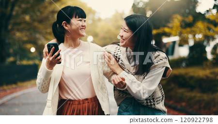 Cellphone, laughing and girl friends in city reading online blog for celebrity gossip together. Happy, night out and Japanese women with phone scroll on social media, internet or mobile app in town. 120922798