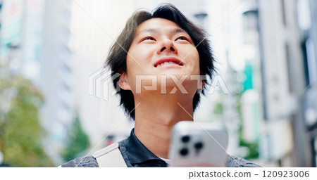 Thinking, man and smile with phone in city for communication, travel location and map notification. Person, mobile and urban view for contact website, morning commute and schedule transport in Japan 120923006