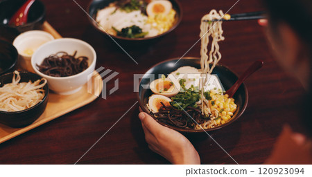 Asian restaurant, ramen and people with noodles, meat and vegetables for dinner, lunch and supper. Culinary, traditional cuisine and customer for healthy eating, nutrition and gourmet dish in Japan Asian restaurant, ramen and people with noodles, meat and vegetables for dinner, lunch and supper. Culinary, traditional cuisine and customer for healthy eating, nutrition and gourmet dish in Japan 120923094