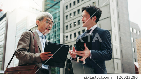 Planning, teamwork and business people in city for documents, development or buildings. Developer, urban planner and mature professional Japanese colleagues speaking of project together in Tokyo 120923286