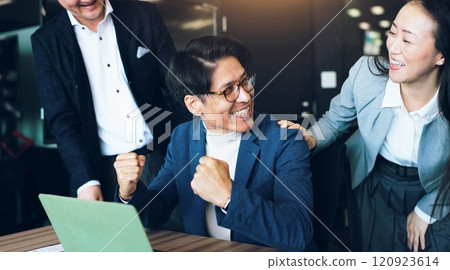 Celebration, group and colleagues with laptop, office and collaboration for media strategist and success. Victory, excited and teamwork for campaign, win and ads for business people and joy in Japan 120923614