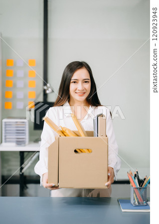 Happy and excited young beautiful Asian woman office worker celebrating her resignation, carrying her personal stuff. leaving job, changing or company. Happy and excited young beautiful Asian woman office worker celebrating her resignation, carrying her personal stuff. leaving job, changing or company. 120923948
