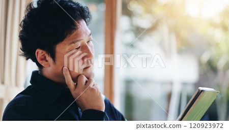 Japanese, man and home with tablet for thinking, reading and bad news of economy with technology. House, male person and serious with digital for online information, research and flare in apartment 120923972