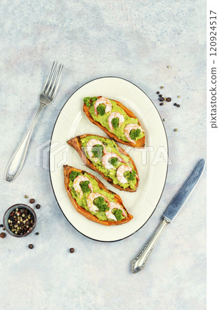 Grilled and stuffed sweet potatoes with prawns. 120924517