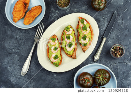 Grilled and stuffed sweet potatoes with prawns. 120924518