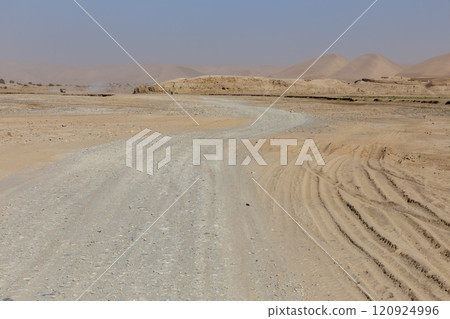 Winding gravel road through arid landscape in Badghis Province, Ghurmach, Afghanistan 120924996