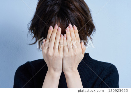 A woman who covers his face with both hands 120925633