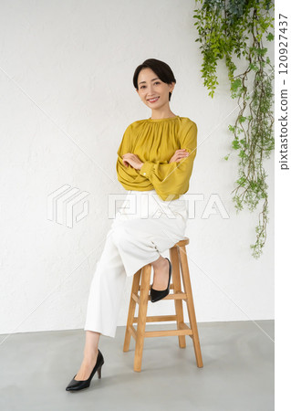 Young woman posing while sitting on a chair in a room 120927437