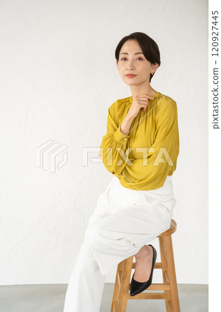 Young woman posing while sitting on a chair in a room 120927445