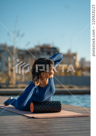 active fitness woman practicing muscular relaxation exercise with massaging foam roller, person stretching with fascial release equipment after sports training, back pain and body stiffness release active fitness woman practicing muscular relaxation exercise with massaging foam roller, person stretching with fascial release equipment after sports training, back pain and body stiffness release 120928225