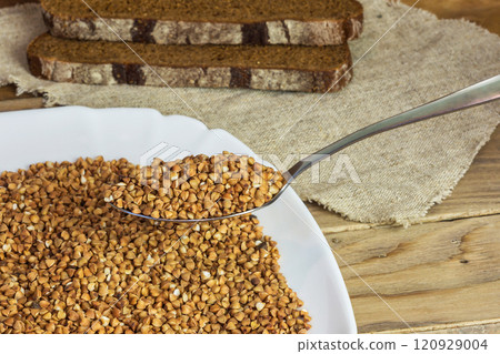On the table is a plate of buckwheat and lies two slices of bread On the table is a plate of buckwheat and lies two slices of bread 120929004