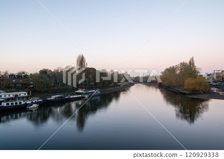 A streetscape of trees and moored boats along the River Thames at sunrise in Kew, a suburb of London A streetscape of trees and moored boats along the River Thames at sunrise in Kew, a suburb of London 120929338