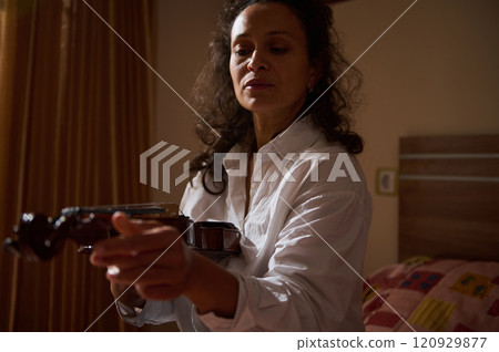 Woman practicing violin in a warmly lit bedroom setting 120929877