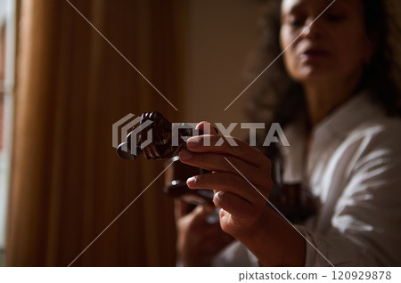 Woman holding a wooden sculpture in dramatic natural lighting indoors 120929878
