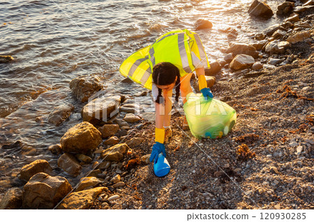 Earth day and environmental conservation. Top view of woman volunteer picking up garbage at beach. Concept of ocean's pollution and recycling garbage 120930285