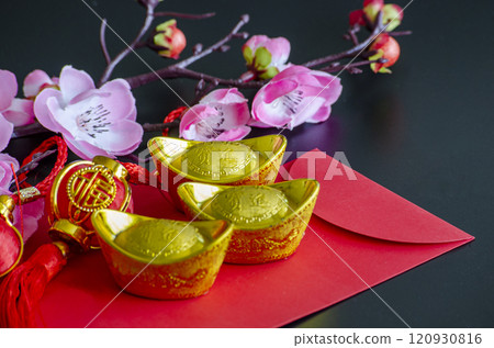 Golden Ingots on top of Chinese New Year red packet. Chinese New Year celebration 120930816