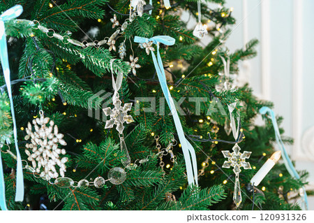 Christmas tree branches adorned with glass ornaments and ribbons on white plaster wall background 120931326