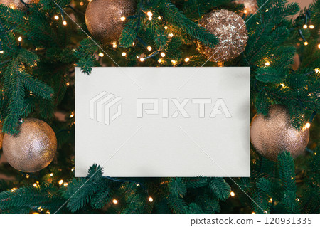 White blank rectangular paper on green Christmas tree branch background. Mockup, template copy space 120931335