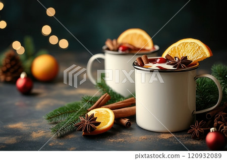Mulled wine in white metal mugs with cinnamon and orange slice on festive background. Copy space for text 120932089