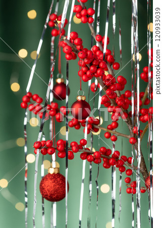 Christmas Ilex and Tinsel with Christmas Balls on Green 120933039