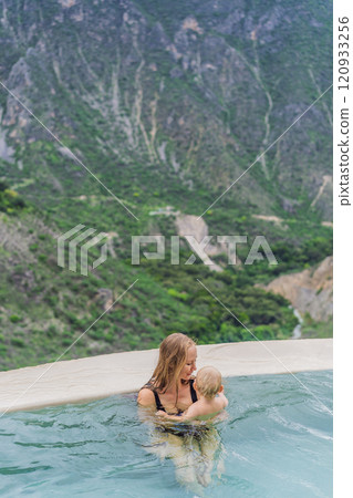 Mother with her toddler son bathing in the hot springs of Grutas Tolantongo, Mexico. Family adventure, relaxation, and natural wellness concept 120933256
