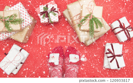 Feet with warm winter socks standing in front of Christmas gifts on red blanket. Top view. Xmas. Flat lay. Feet with warm winter socks standing in front of Christmas gifts on red blanket. Top view. Xmas. Flat lay. 120933817