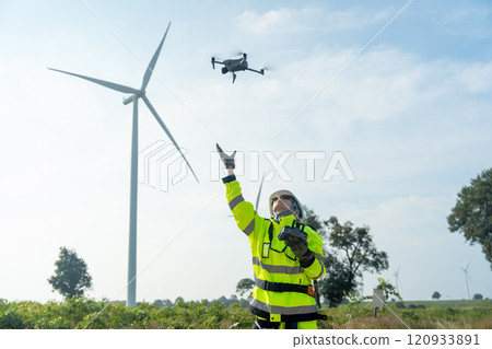 Wind turbine or windmill worker woman or technician control drone to work in workplace field during day time. Wind turbine or windmill worker woman or technician control drone to work in workplace field during day time. 120933891
