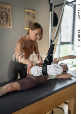 A detailed closeup of a foot work and core exercise on a Balanced Body Reformer machine illuminated by sunlight 120933905