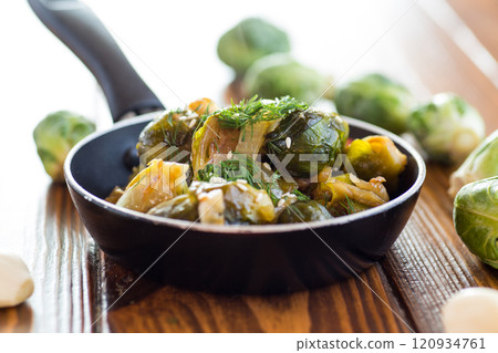 Brussel sprouts cooked with vegetables and spices, on a wooden table Brussel sprouts cooked with vegetables and spices, on a wooden table 120934761