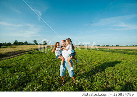 Three sisters are playing in nature in the grass. Three sisters are playing in nature in the grass. 120934799