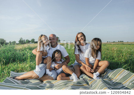 Farmer family with little daughter walking through grass field. Mom dad girl walking together holding hands Farmer family with little daughter walking through grass field. Mom dad girl walking together holding hands 120934842